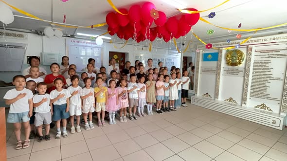 Мектеп мұғалімдері мен оқушылар бір мезгілде Әнұранды орындады
